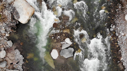 Aerial view of a river stream in the mountains. Top view of a river stream through the rocks.
