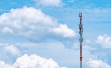 Telecommunication tower with blue sky and white clouds background. Antenna on blue sky. Radio and satellite pole. Communication technology. Telecommunication industry. Mobile or telecom 4g network.