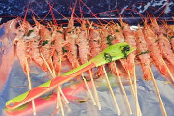 Shrimps lie on a plate with foil for cooking in the oven