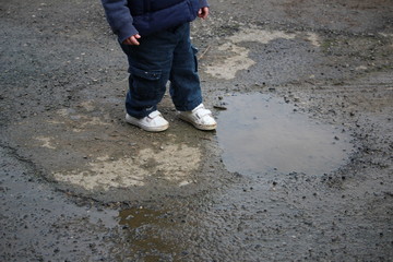 enfant qui joue dans une flaque d'eau