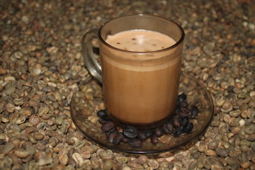 A cup of white coffee in on the coffee beans