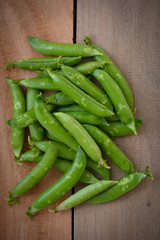Fresh green peas on wooden background