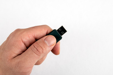 USB memory stick in male hand on white background with copy space