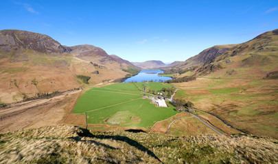 Obraz premium Views of Gatesgarth and lake Buttermere from Fleetwith Pike ridge on a sunny blue sky day in the Lake District.