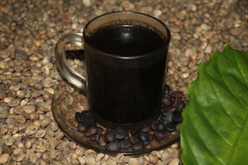 A cup of black coffee in on the coffee beans
