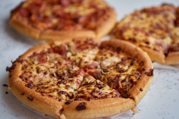 Three american style pizzas served on a table