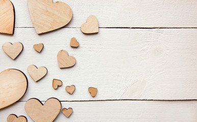 Fototapeta premium A beautiful background with lot of wooden hearts on the white table