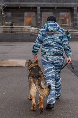 Female police officers with a trained dog. German shepherd police dog. Russian Police. Sign means 