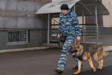 Female police officers with a trained dog. German shepherd police dog.