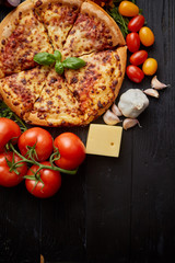 Delicious italian pizza served on black wooden table