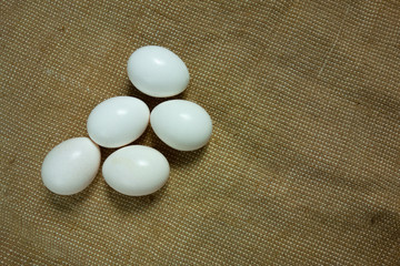 Five eggs on bagging fabric closeup view. Easter background with copy space. Traditional farming healthy food product. Protein nutrition source