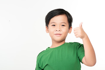 Smiling boy in white t-shirt showing thumb up on a light background