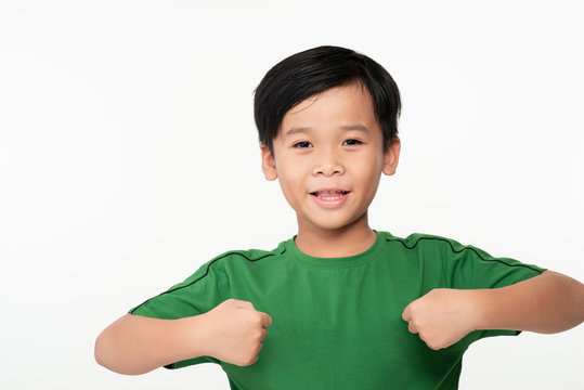 Portrait Of Cute Smart Young Asian Boy Shows Winning Gesture And Smiling At Camera, Celebrating Success Victory Against White Background