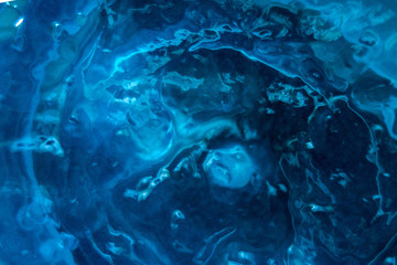 Textured blue substance background. Foam consistence backdrop closeup view of gel, mousse or water. Mock-up or template for design banner and poster