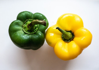 Green and yellow bell pepper on white background