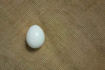 Egg on bagging fabric closeup view. Easter background with copy space. Traditional farming healthy food product. Protein nutrition source
