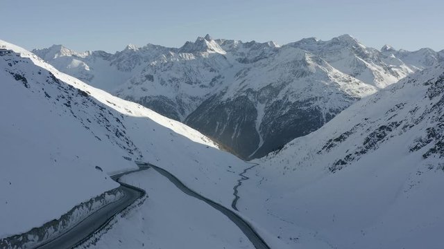 Aerial sidewards dolly, capturing a vehicle travelling along Passo del rombo.