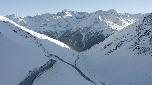 Aerial shot, overlooking view of Passo del rombo and a car driving down the street.