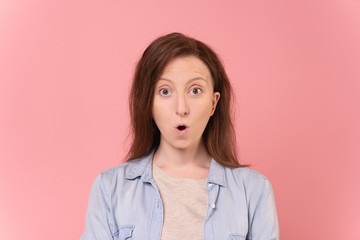 Close-up portrait of a funny shocked young caucasian woman posing over pink background. Young woman was surprised at the discounts and personal offer. Advertising space