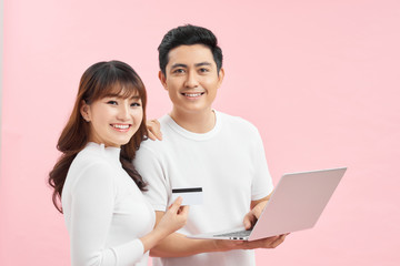 happy attractive smiling couple man and woman with credit card and laptop