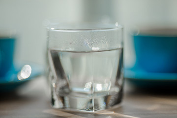 Close-up view of the blue coffee mug, clear glass for drinking water, placed on a tray to bring clear drinks, seen at resorts, hotels or bakeries