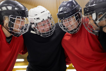 Portrait of female hockey team huddling happily before sports match, copy space