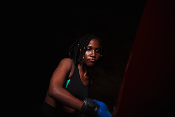Fototapeta na wymiar beautiful woman with the blue boxing gloves, dark background