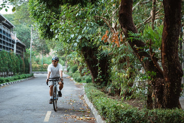 Asian young man ride road bikes on the road in the morning