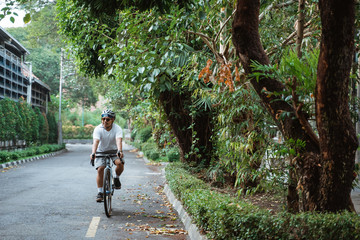 Fototapeta premium Asian young man ride road bikes on the road in the morning