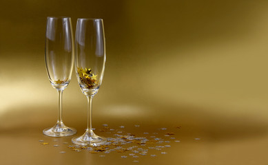 Champagne Glasses with golden stars confetti stock images. Champagne Glasses on a golden background. Festive background with golden stars. Elegant golden holiday background with copy space for text