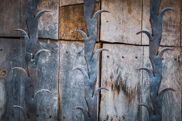 Detail of an antique wooden door with cast iron decorative bars