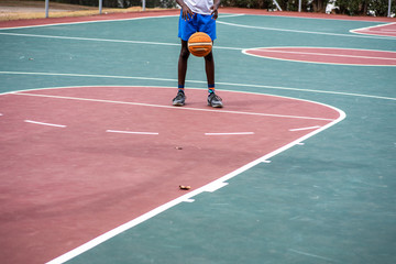 Obraz premium Young boy practicing his free throws on court