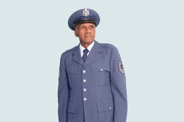 Senior male US Air Force officer standing over light blue background