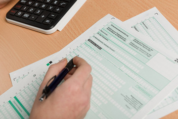 a woman's hand filling out a tax declaration