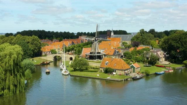 Aerial pull back dolly shot from the windmill on the riverside in the ancient city of Sloten in the Netherlands