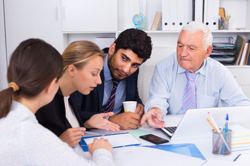 Fototapeta premium Office workers are writing financial reports and discussing with mature boss