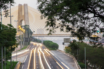 Sunrise, beginning of the day in metropolis, bright lights and vehicles in transit. Sao Paulo city...