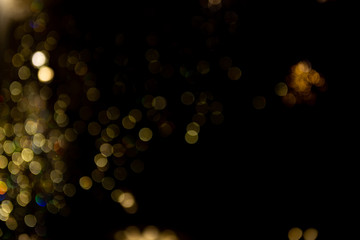 Abstract bokeh made from Christmas lights in the shop on black background. Holiday concept, overlay for your images.