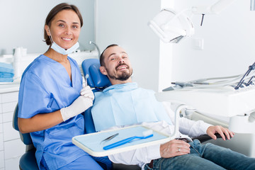 Man is satisfied in chair after treatment in dental office