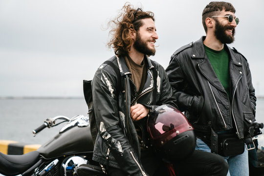 Photo of bearded joyful men bikers smiling and talking