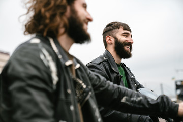 Photo of bearded cheerful men bikers smiling and talking