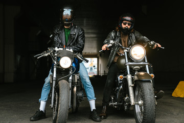 Photo of bearded brutal men bikers on bikes wearing helmets