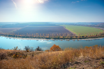 Rural autumn landscape. View from the high bank of the river to the valley on the opposite bank. River in the fall. Beautiful nature