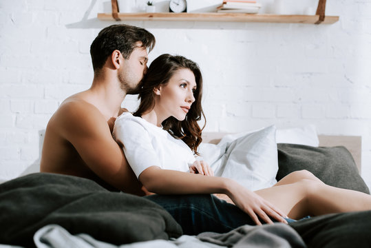 selective focus of man kissing head of attractive girl at home