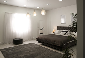 Stylish room interior with large comfortable bed