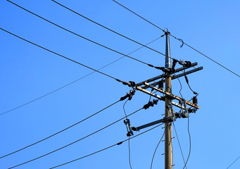 Electric pole with wires, blue sky.