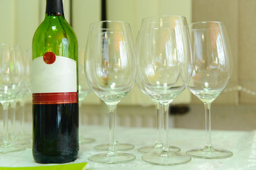 Bottle of cold vodka and wine bottle in bucket with ice and orange juice in jug on table, copy space. Alcohol bottles in ice bucket in restaurant. Wedding party.