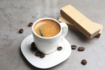 Delicious coffee and wafers for breakfast on grey table
