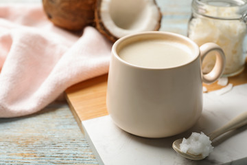 Fototapeta na wymiar Delicious coffee with organic coconut oil on white wooden table