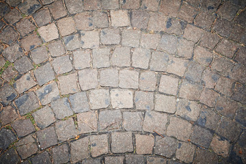 Paving stones pathway texture with sprouting green grass between the stones
